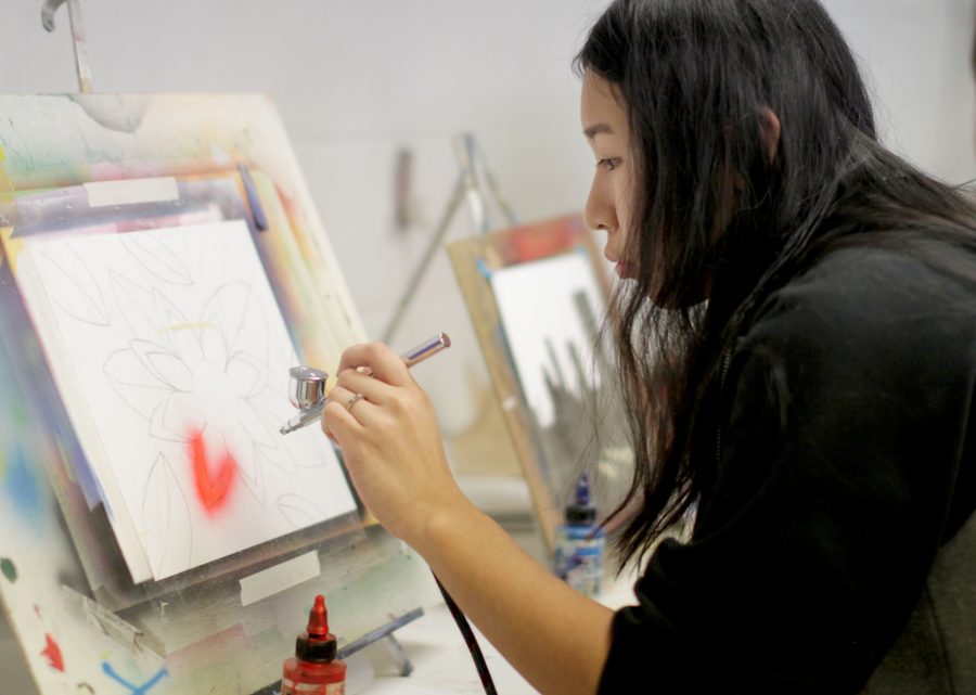 With a steady hand, senior Korryn Asuncion sprays her drawing of a flower with her air brushing tools in G3 Air Brushing. Asuncion used masking film to keep the color from going places she didn’t want it to go. “This was my first year in Air Brushing and it was difficult at first to control the stream of paint,” Asuncion said. “As the semester progressed, I grasped it and was pleasantly surprised with my work.”