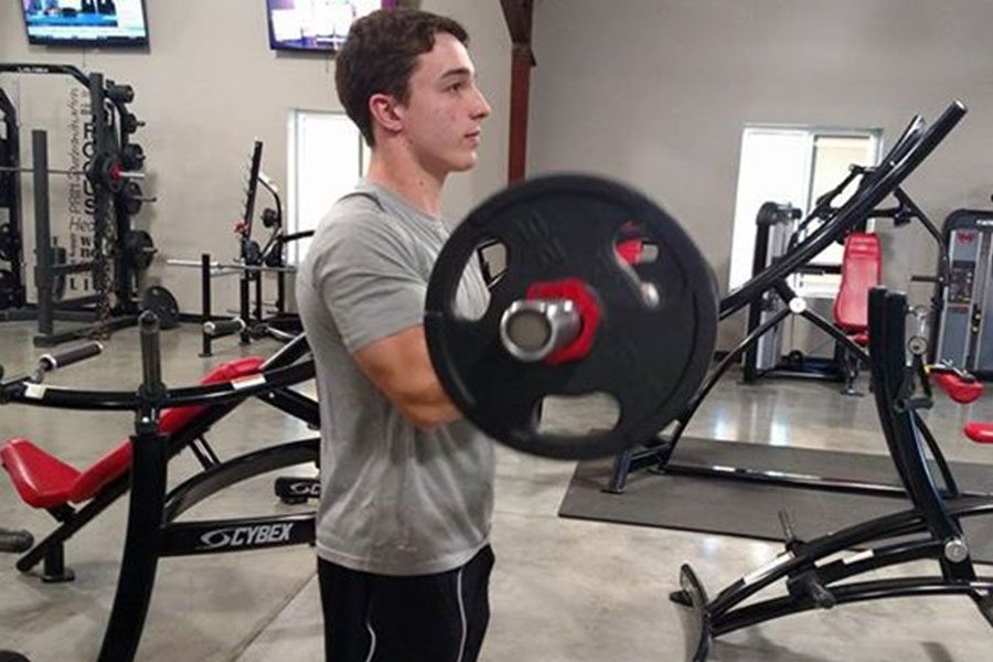 Sophomore Garret Rymer lifts weights at Munsch Fitness after school. 