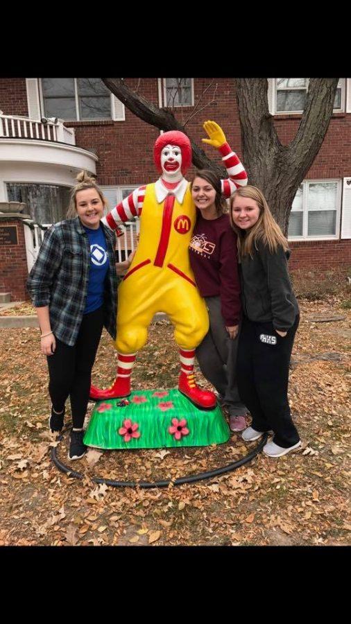 Seniors Kristen Nease, Madisyn Keller and Brianna Brin stand with the Ronald statue in front of Sleep Hollow house.