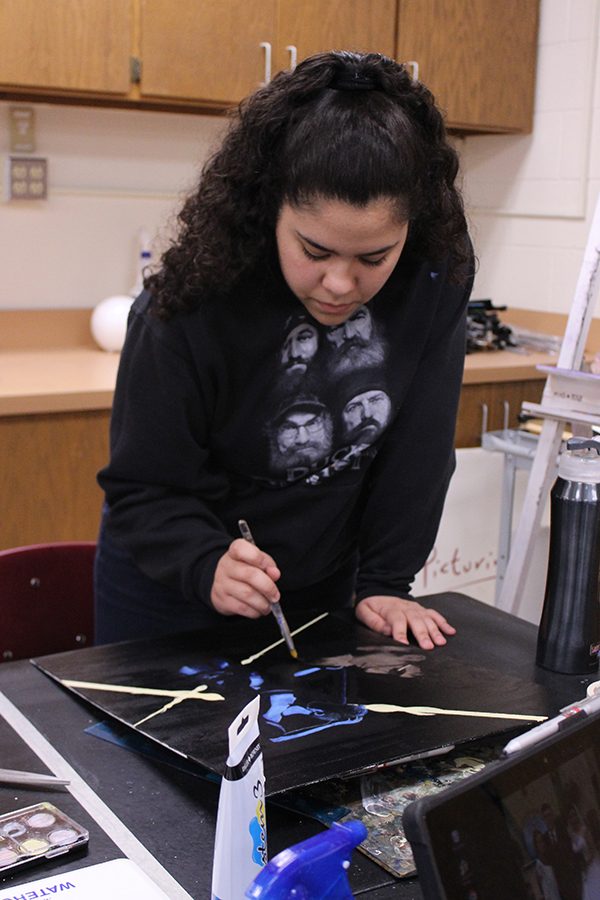Sophomore Iris Garibay works on a painting in during class.