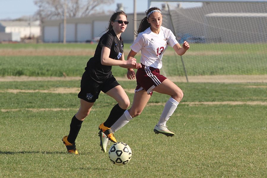 Sophomore Kallie Leiker runs alongside an opposing team member during a recent home game.