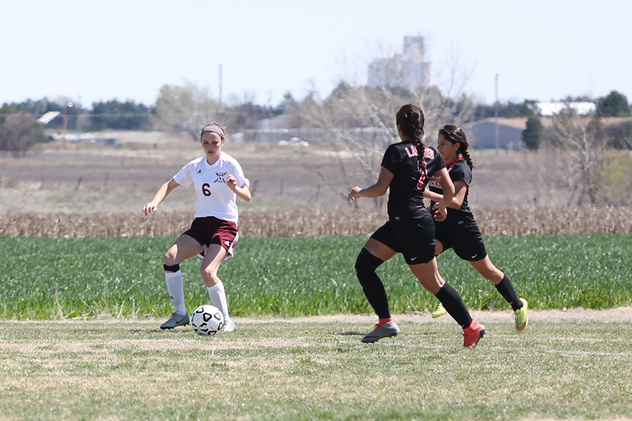 Sophomore  Hannah McGuire takes on two Great Bend defenders in a recent home game.