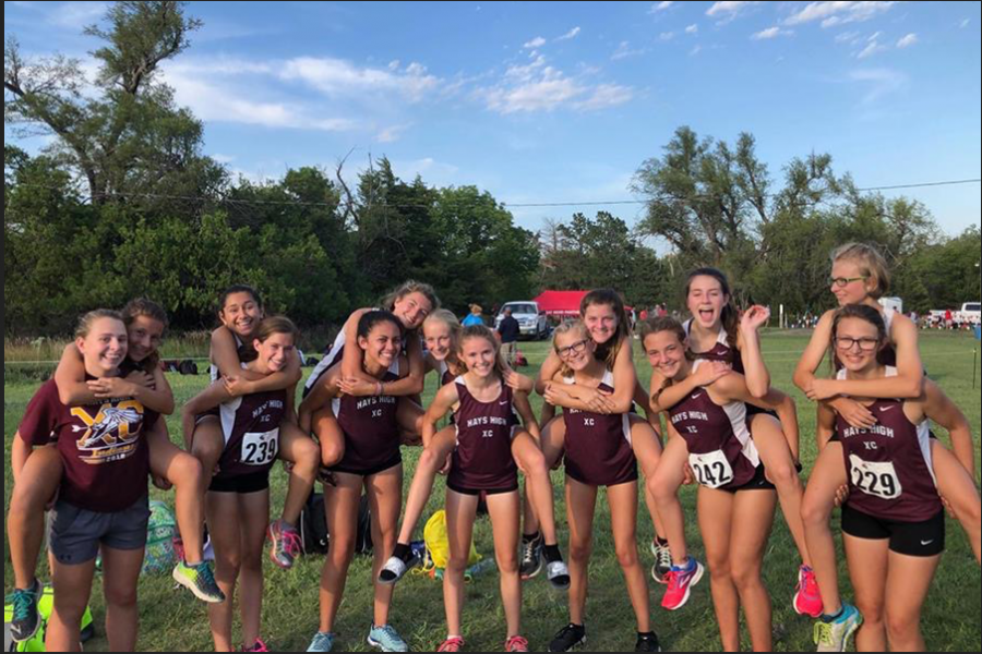 The girls XC team smiles for a photo after the race. 