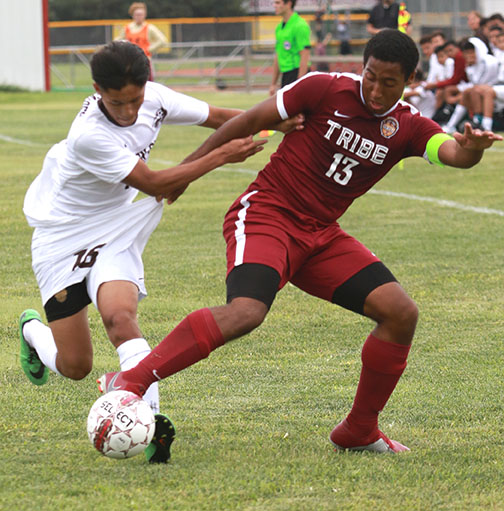 Senior Trey McCrea fights off Garden City Defender to keep control of the ball.