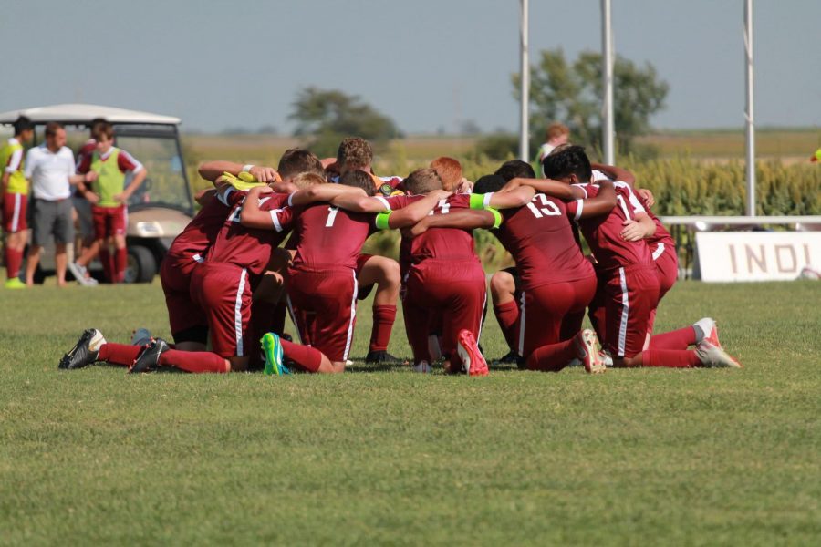 2018 boys soccer team circles up before game as their pre-match ritual.