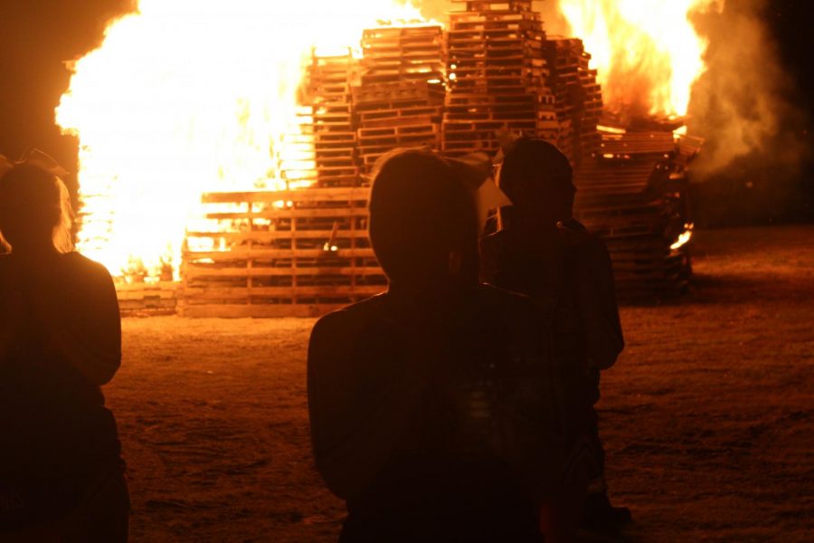 Cheer leaders perform in front of the bonfire.