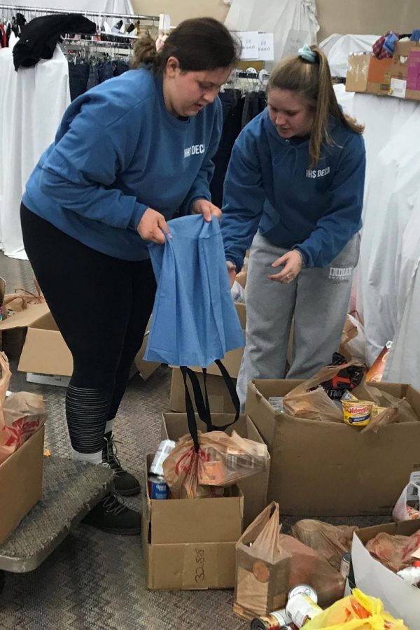 Senior Shyann Schumacher and junior Cassidy Prough set cans down to be counted and sorted. This is Schumachers second year helping and Proughs first year.