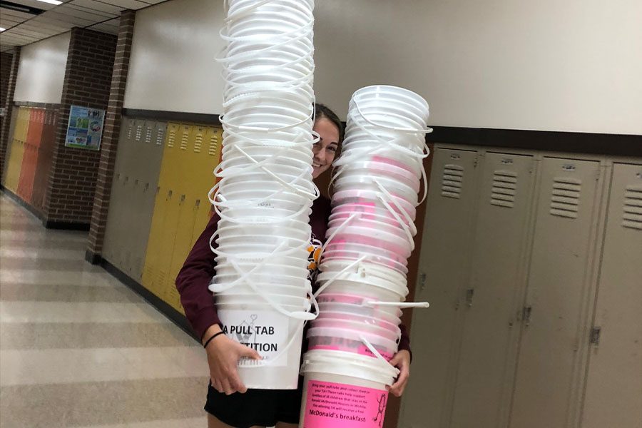 Seniors Kallie Leiker carries donation buckets to prepare for a pull tab competition. Their project, the Ronald McDonald house charity, accepts pull tabs to allow families to spend nights.