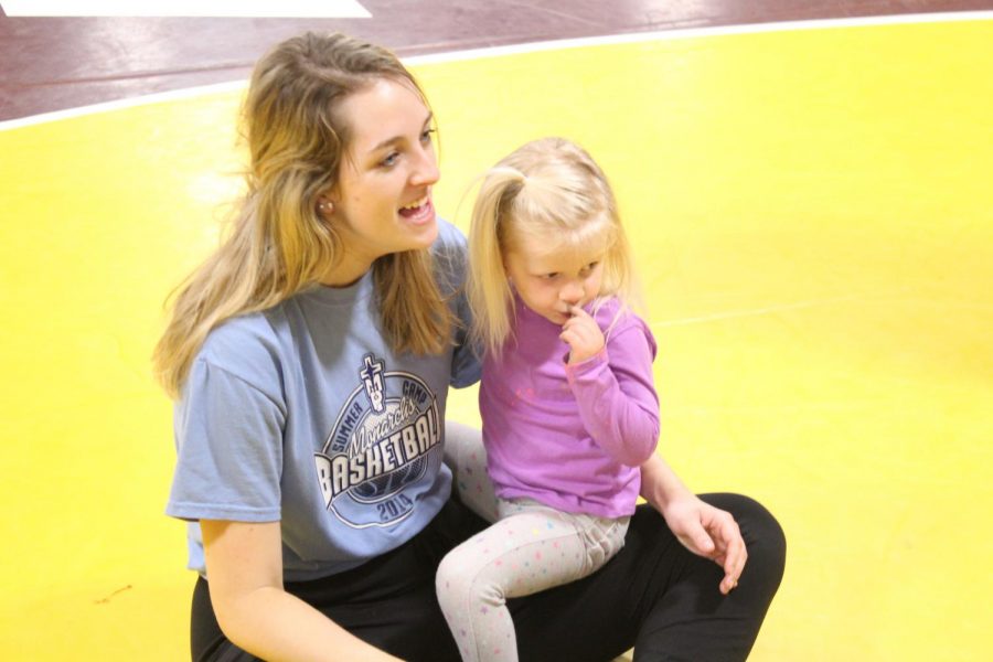 Senior Emma Malleck holds little girl during family studies in the wrestling room last fall semester. Students this semester will start to interact with little kids January 31st. 