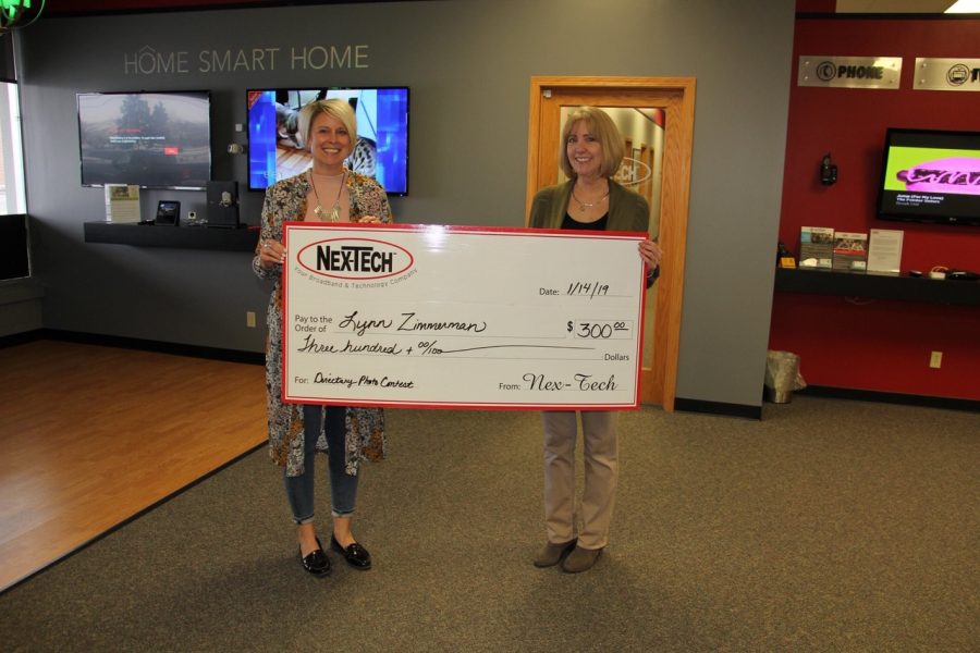 Instructor Lynn Zimmerman accepts her check from Nex-Tech. She recently won a Nex-Tech contest and her photo was put on the front cover of the directory.