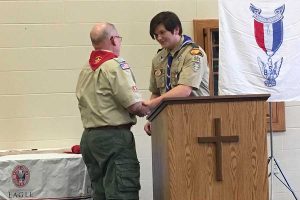 Junior Marshall Perryman giving his grandfather, Clifton Ottaway, a mentor pin. He was to give the mentor pin to someone who has helped him through his journey in becoming an Eagle Scout.