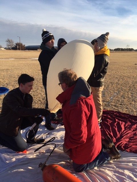Seniors Garret Rymer, Spencer Wittkorn, Benton McGrath and Cameron Karlin help fill the balloon with helium. 
