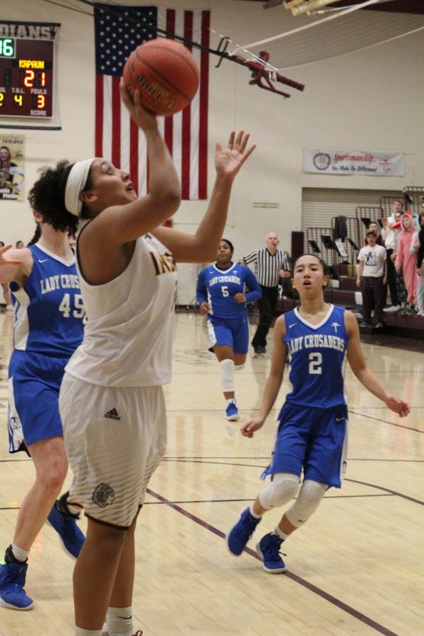 Freshman Taleia McCrae attempts a basket at the first round of Sub-State at home against Kapaun Mt. Carmel. The Indian basketball team ended its season 14-8 after a loss against the Goddard Lions.