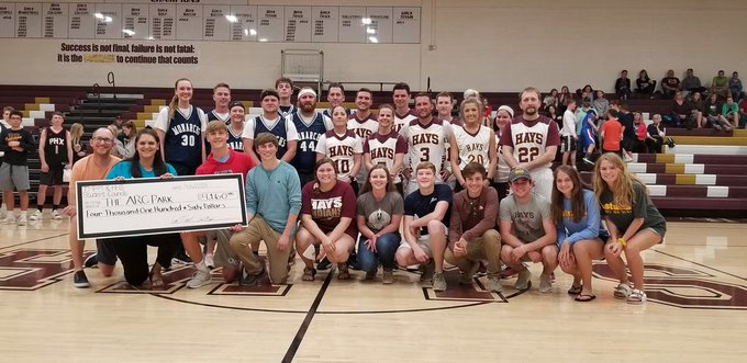 The two basketball teams and StuCo groups stand with the check for the Arc of Central Plains. The two groups were able  to present them with a 4000 dollar check to help fund the ARC Park.