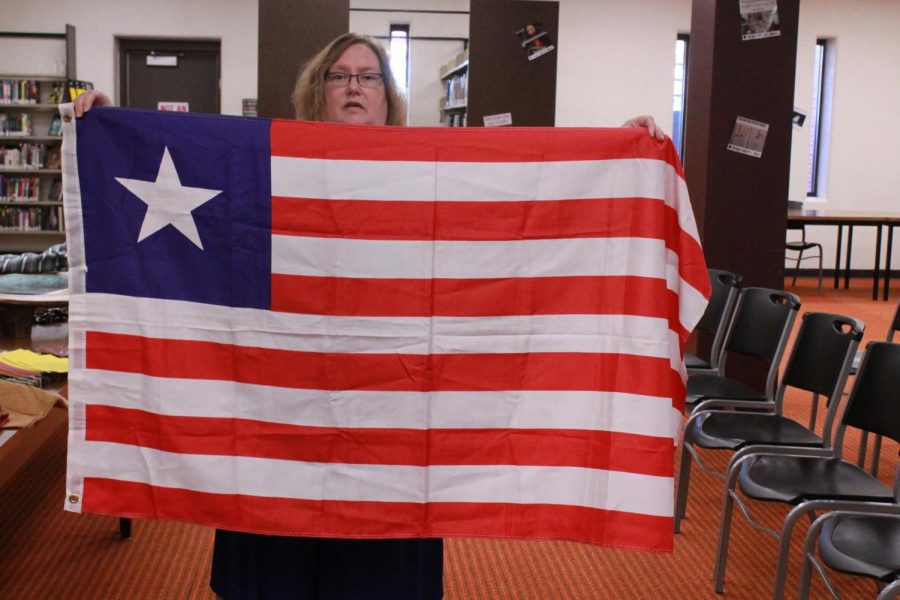 Folkerts holds up the Liberian flag. The flag was based off of the United States, taking the stripes and blue background and using one star to represent the one country. 