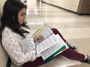 Sophomore Alisara Arial takes a few minutes to study her solo score in the hallway during seminar. The KSHSAA Regional Solo and Small Ensemble Festival will take place on March 6 at Barton Community College.