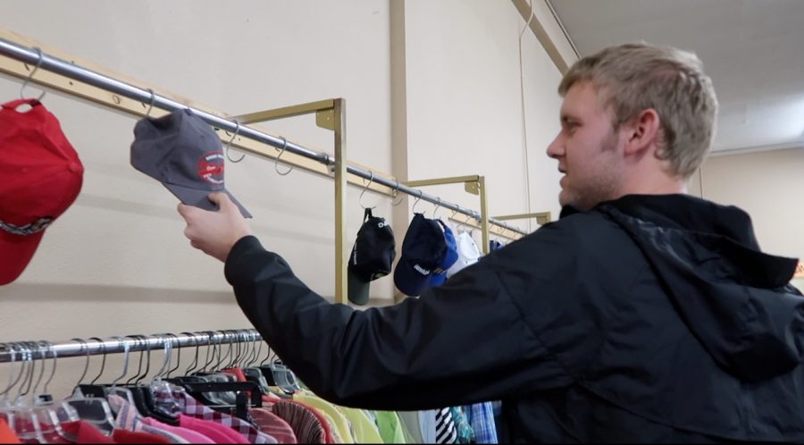 Senior Calvin Duden looks at hats at the local thrift store The Arc.