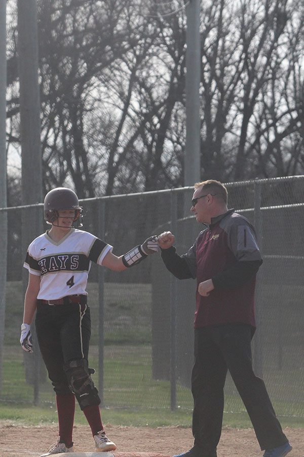 Junior Madelyn Waddell on first being congratulated by coach on first.