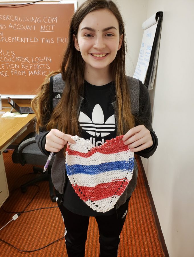 Junior Madison Stanton holds a dishcloth she knit and donated last year during Knitting Club. The club takes on multiple service projects throughout the year such as making lap blankets for nursing homes and scarves for the Special Olympics. 