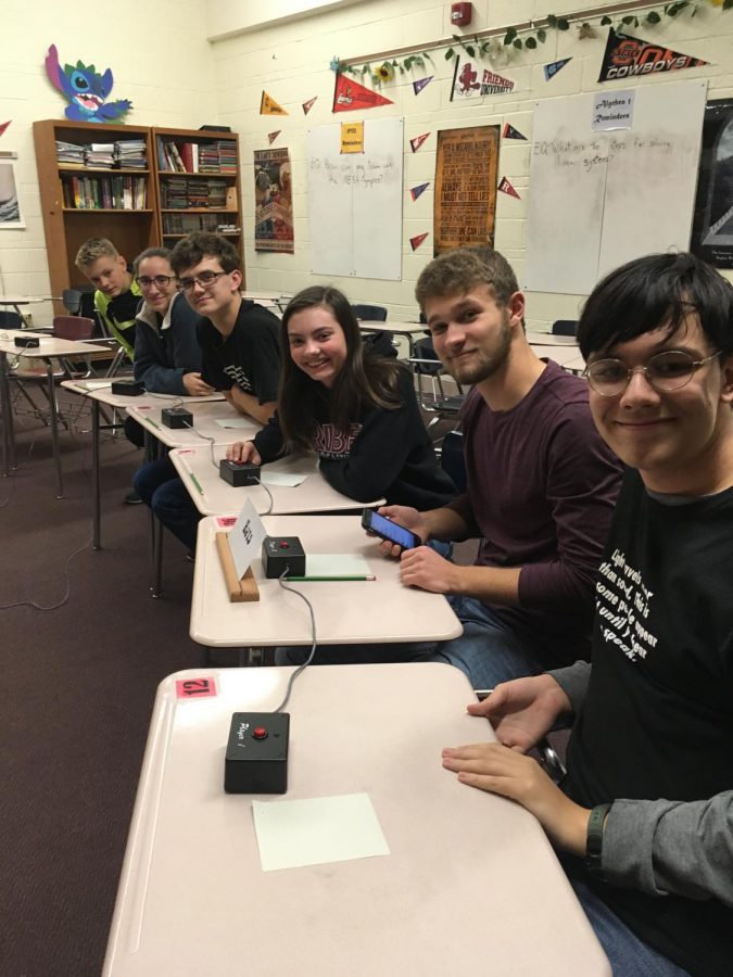 Varsity Scholars Bowl sits at desks with buzzers during the meet on Nov. 21. The team made it to semifinals, falling to Salina South. 