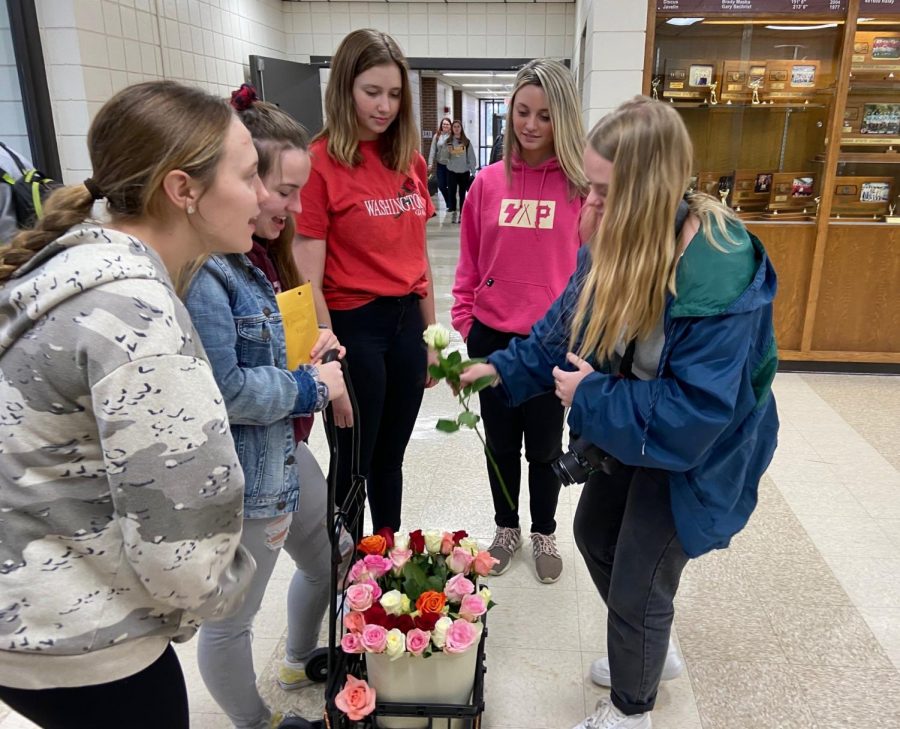 Members of Foreign Language Honor Society sell a rose to senior Emma Pfannenstiel on Feb. 13.  This was the societys second year selling roses for Valentines Day.