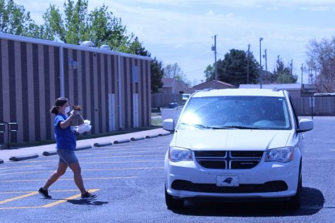 On April 29, one of the volunteers of the free drive-up meal service delivers some meals to a family at Hays Middle School. All children ages 1-18 can receive a free meal. The child does not need to be enrolled in USD 489.