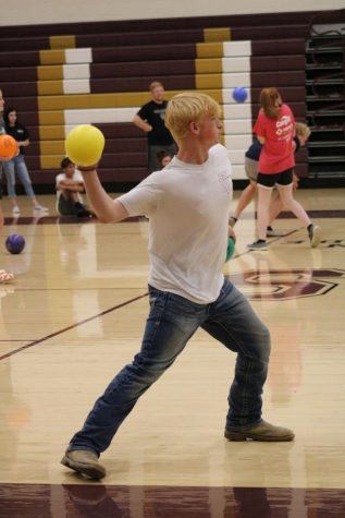 Junior Kyle Mortensen throws the yellow dodgeball during the team building activity. 