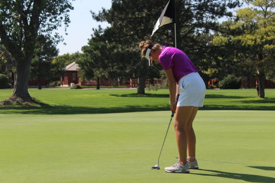 Junior Gracie Wente sinks a putt at the the Hays High Invitation Golf Tournament at Smoky Hill Country Club.