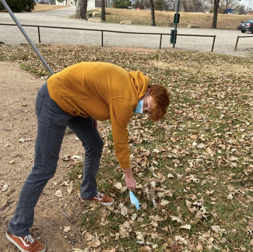 Senior Skylar Zimmerman picks up a dirty mask. This was to complete the Cleanup Crew task where a member of the team needed to properly dispose of litter found during the hunt.