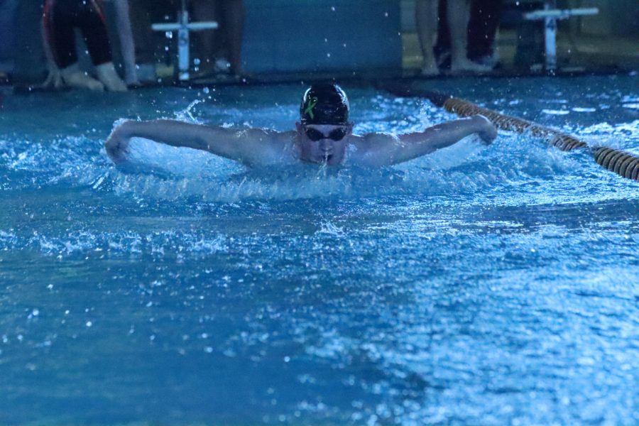 Junior Tyler Solida competes in a race using the butterfly stroke during the HHS home meet at the Center for Health Improvement 