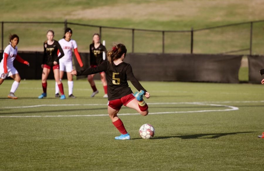 Senior Maggie Robben kicks the ball while playing against Liberal on April 22. Soccer has been one of the many sports affected by cancellations.