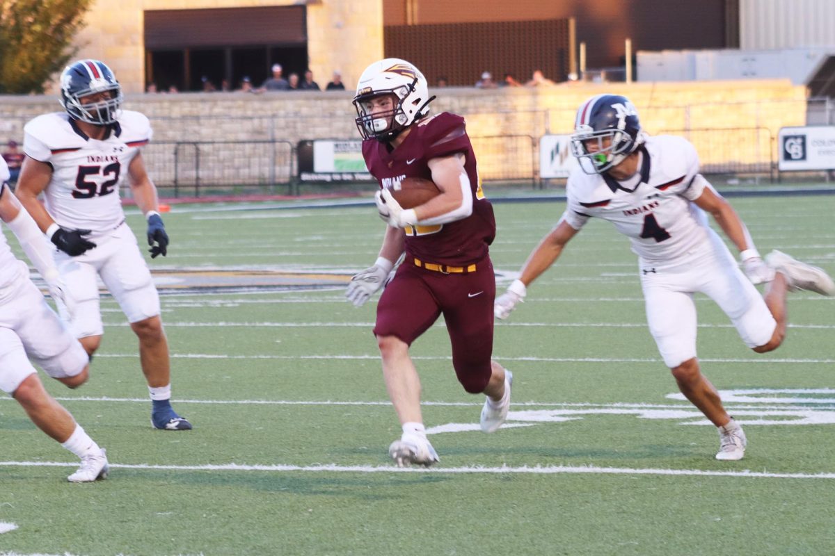 Junior running back Holden Lind gets past the Manhattan defense on his way to the end zone.