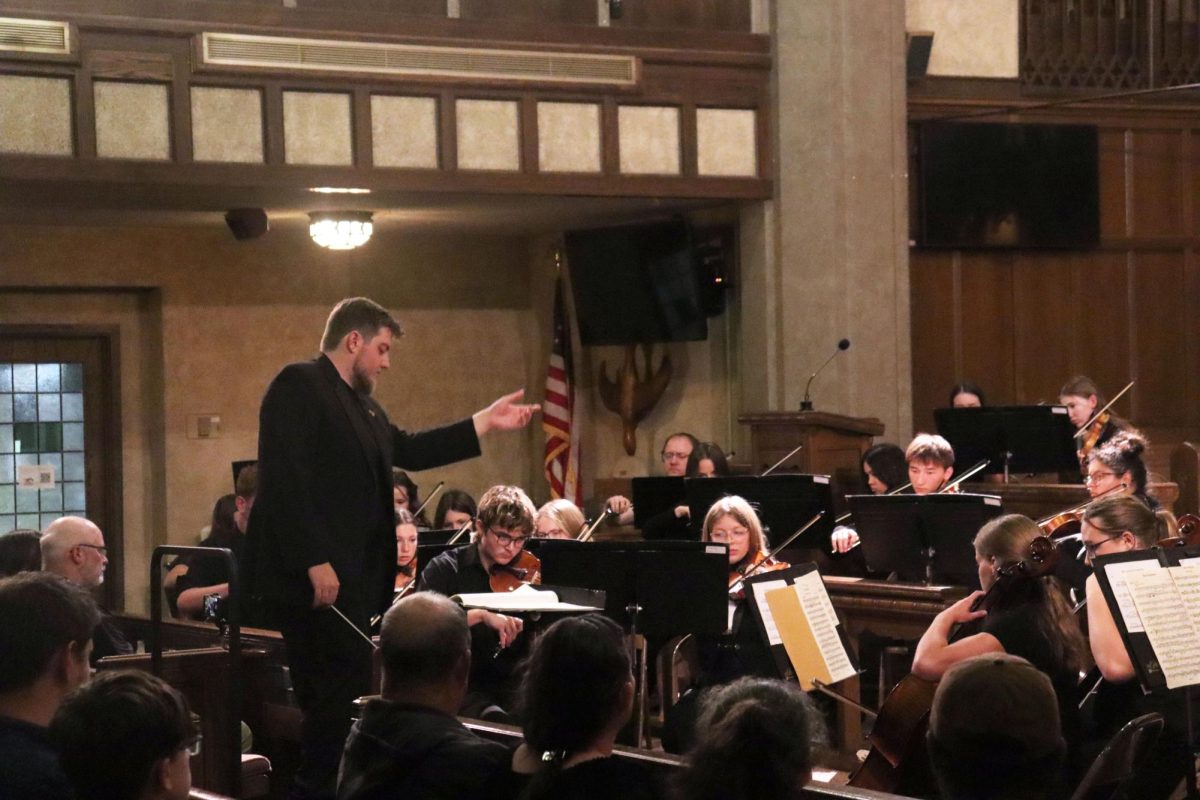 Orchestra teacher Brayden Smith conducts the group of Hays High School Strings, Beloit High School Strings, and professional Winds.