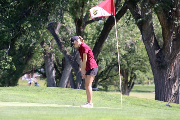 Junior Liz Cunningham prepares to swing at a meet in Hays earlier this season. 