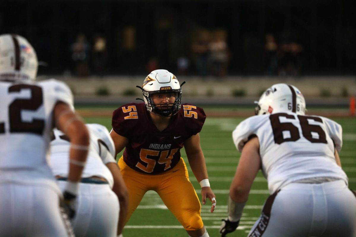 As the Hays High Indians prepare for their next down, senior Jaxson Chartier braces to hold back the defense of Garden City at the new Hays High football field on Sept. 26.