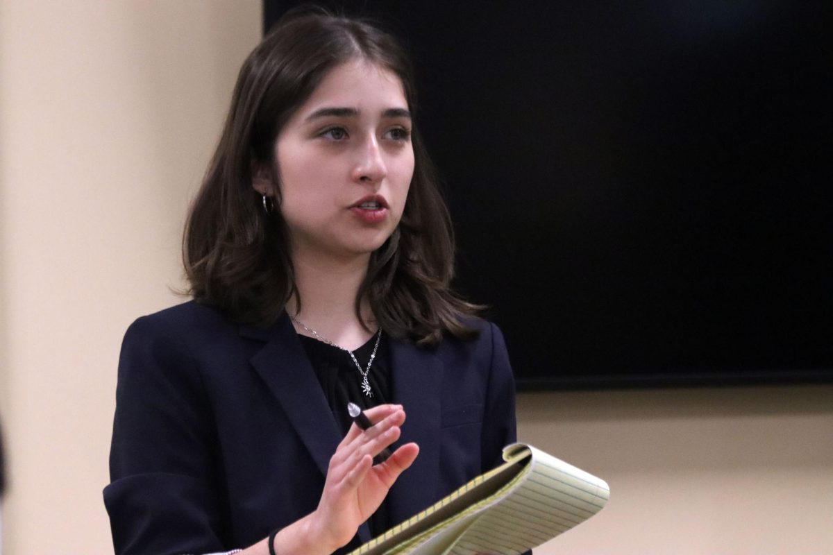 As the debate round commences, senior Sophia San Martin debates her opponent at the home Hays High debate tournament on Dec. 13.